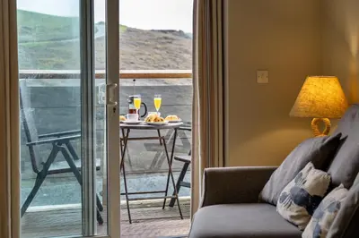 a living room with a couch and a table with drinks at Finest Retreats - 25 The Waves in Porth