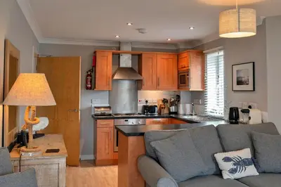 a living room with a couch and a kitchen at Finest Retreats - 25 The Waves in Porth