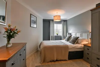 a bedroom with a bed with a dresser and a window at Finest Retreats - 25 The Waves in Porth