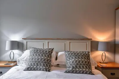 a bedroom with a bed with two lamps and two pillows at Finest Retreats - 25 The Waves in Porth