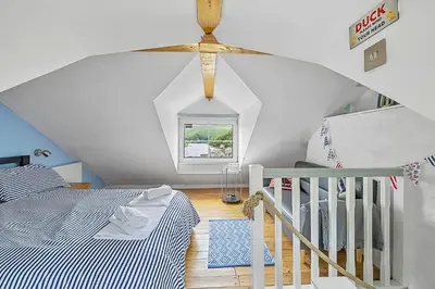 a bedroom with a bed and a ceiling fan at Finest Retreats - Farleigh Cottage in Looe