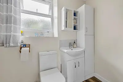a white bathroom with a toilet and a sink at Finest Retreats - Farleigh Cottage in Looe