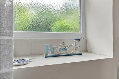 a window sill with a sign in front of a window at Finest Retreats - Farleigh Cottage in Looe