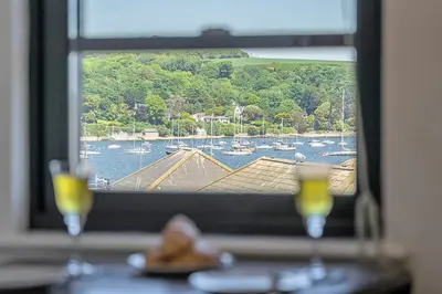 two glasses on a table with a view of a harbor at Finest Retreats - Williams Court in Falmouth