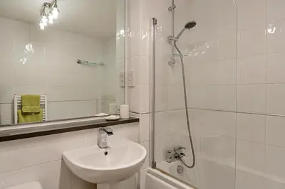 a white bathroom with a shower and a sink at Finest Retreats - Williams Court in Falmouth