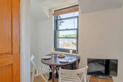 a dining room with a table and a window at Finest Retreats - Williams Court in Falmouth