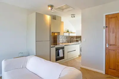a white kitchen with a bed in a room at Finest Retreats - Williams Court in Falmouth