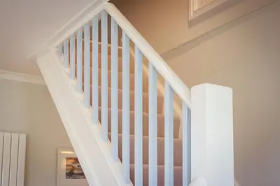 a white staircase with white railings in a house at Compass Rose in Port Isaac