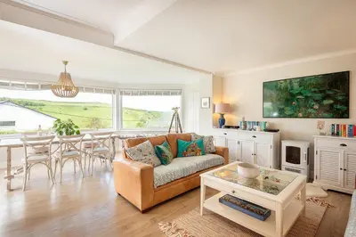 a living room with a couch and a table at Compass Rose in Port Isaac