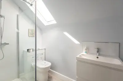 a white bathroom with a toilet and a sink at Compass Rose in Port Isaac