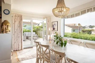a dining room with a table and chairs and a large window at Compass Rose in Port Isaac