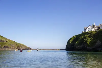 a house on a hill in the middle of a body of water at Compass Rose in Port Isaac