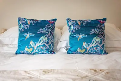 two blue pillows sitting on top of a bed at Compass Rose in Port Isaac