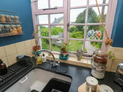 a kitchen counter with a sink and a window at Mermaid Cottage in Helston