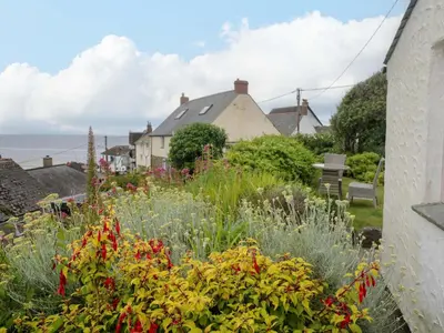a garden with colorful flowers in a house at Mermaid Cottage in Helston