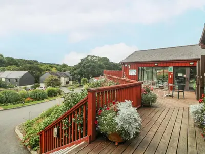 a wooden deck with plants and a building at Trouts Reach in Falmouth