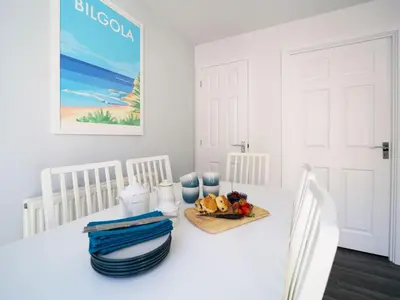 a white dining room with a white table and chairs at Canyke Fields in Bodmin