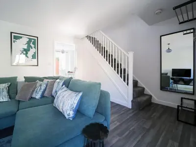 a living room with a blue couch and a staircase at Canyke Fields in Bodmin