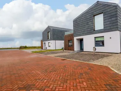 a house with a grey roof and a brick driveway at 8 Karn Havos in Wadebridge