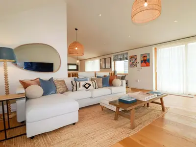 a living room with a white couch and a table at 8 Karn Havos in Wadebridge