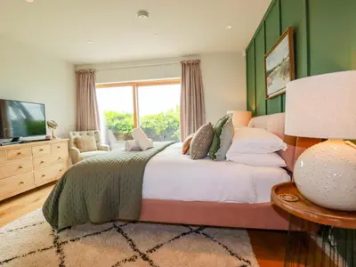a bedroom with a large bed and a television at 8 Karn Havos in Wadebridge