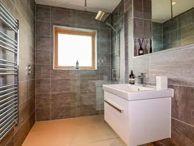 a bathroom with a white sink and a window at 8 Karn Havos in Wadebridge