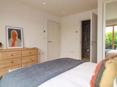 a bedroom with a bed and a dresser and a mirror at 8 Karn Havos in Wadebridge