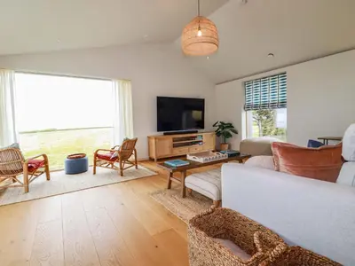 a living room with a couch and a tv at 8 Karn Havos in Wadebridge