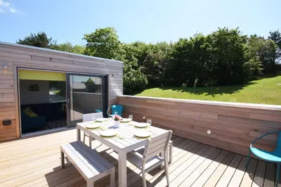 a patio with a table and chairs on a deck at House 18 in Looe