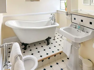 a white bathroom with a tub and a sink at Bora House in Newquay