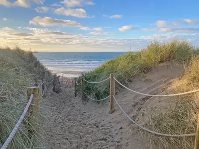 a sandy path to the ocean on a beach at Bora House in Newquay