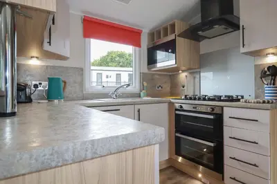 a kitchen with a sink and a stove top oven at The Maples, no 56 in St Austell