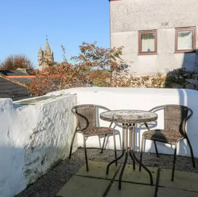 two chairs and a table on a patio at Falmouth Retreat - Family stays in Falmouth