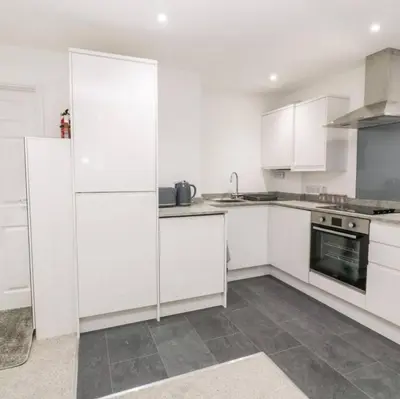 a white kitchen with white cabinets and appliances at Falmouth Retreat - Family stays in Falmouth