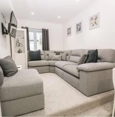 a living room with a sectional couch and a chair at Falmouth Retreat - Family stays in Falmouth
