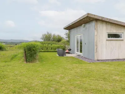 a small shed in a field with a grass yard at The Tinystore in Bodmin