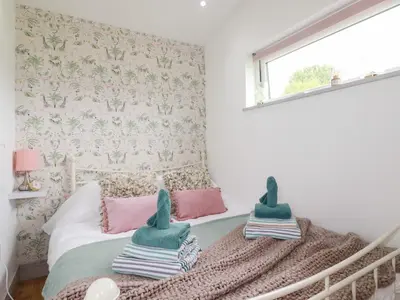 a bedroom with a bed with two dolls on it at The Tinystore in Bodmin