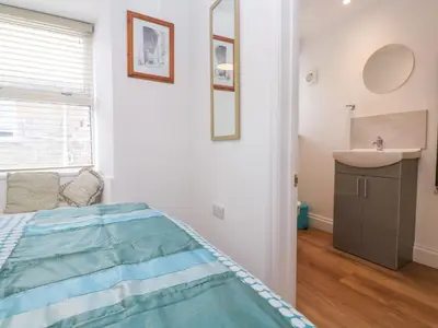 a bedroom with a bed and a sink at Rockpools, 23 Carncrows Street in St Ives
