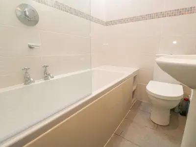 a bathroom with a tub and a toilet and a sink at Rockpools, 23 Carncrows Street in St Ives