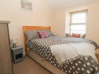 a bedroom with a bed and a window at Rockpools, 23 Carncrows Street in St Ives