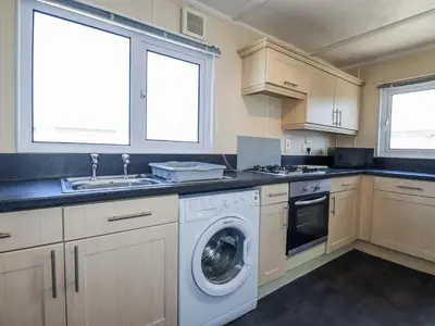 a kitchen with a washing machine and a sink at Lazy Days in Padstow