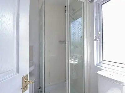 a bathroom with a glass shower and a toilet at Lazy Days in Padstow