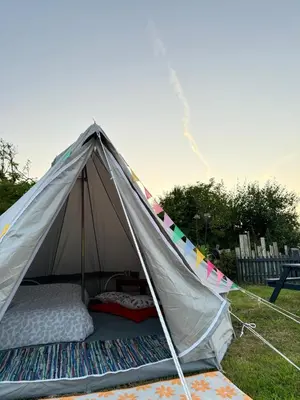 a tent with a bed in it in a field at Emilies Bell Tent in St Ives