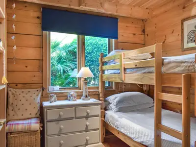 a bedroom with bunk beds and a window at Maple Leaf Cottage in Padstow