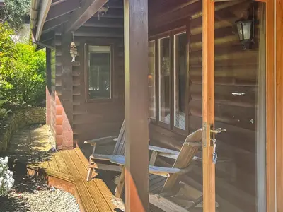 a chair sitting on the porch of a cabin at Maple Leaf Cottage in Padstow