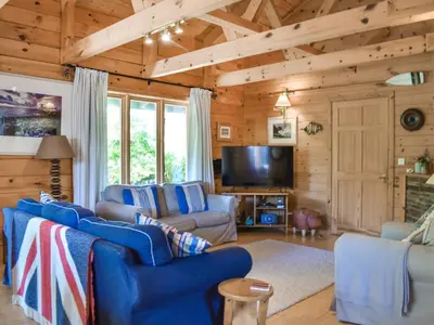 a living room with blue chairs and a flat screen tv at Maple Leaf Cottage in Padstow
