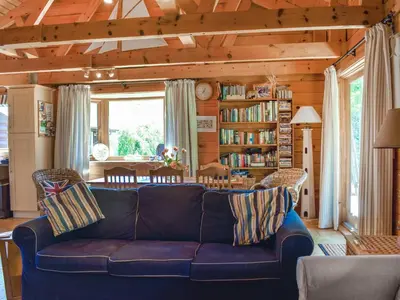 a living room with a blue couch in a room at Maple Leaf Cottage in Padstow