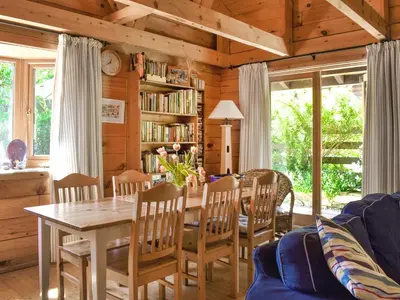 a living room with a table and chairs at Maple Leaf Cottage in Padstow