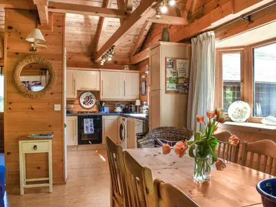 a kitchen and dining room with a wooden table at Maple Leaf Cottage in Padstow