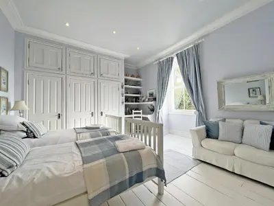 a white bedroom with a bed and a couch at Trenare in Truro